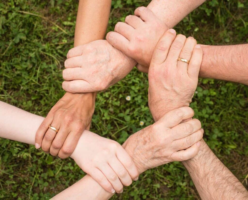 Diverse hands joined together symbolizing community support and unity.